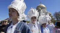Para gadis menghadiri perayaan peringatan 318 tahun kota Kronstadt, di luar St. Petersburg, Rusia (21/5/2022). (AP Photo/Dmitri Lovetsky)