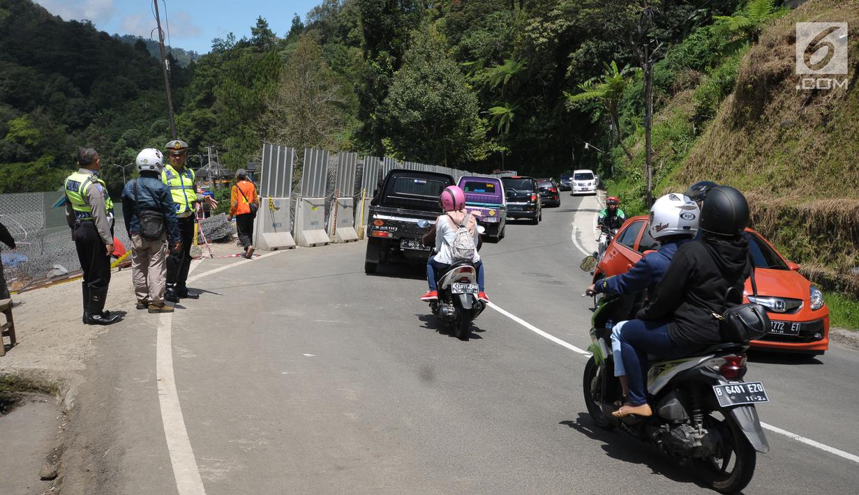 Petugas mengawasi arus lalu lintas di sekitar area yang longsor di kawasan Ciloto, Cianjur, Jabar, Sabtu (31/3). Longsor yang terjadi pada Rabu (28/3) lalu diduga adanya pergerakan tanah sehingga menyebabkan longsor. (Liputan6.com/Helmi Fithriansyah)