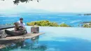 Kali ini Ammar terlihat berada di tepi kolam renang yang bersebelahan dengan hamparan laut luas sepertinya. Rona bahagia terpancar dari pemeran sinetron Anak Langit ini. (Instagram/ammarzoni)