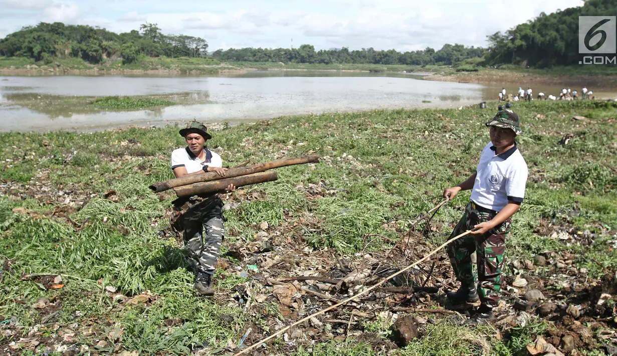 Personel TNI AL mengumpulkan kayu di sungai Citarum di Desa Warung Pulus, Bandung Barat, Jawa Barat, Minggu (17/12). Memperingati HUT TNI AL ke 72, melaksanakan operasi bakti TNI AL dengan menggelar acara "Bebersih Citarum". (Liputan6.com/Herman Zakharia)