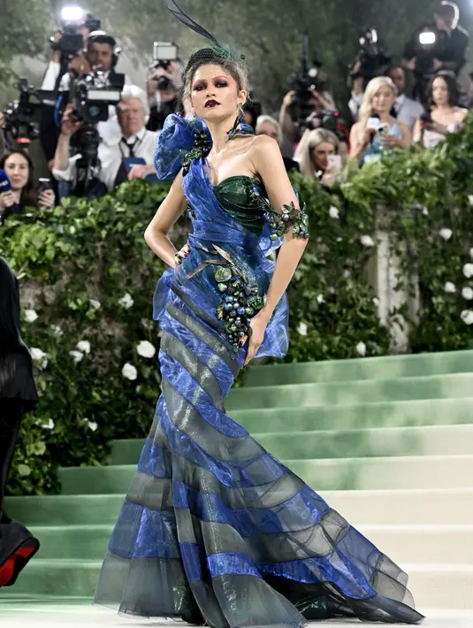 Gaun one off shoulder  ini menampilkan rok terompet panjang yang dilapisi garis diagonal berwarna biru royal dan hijau zamrud.  (Photo by Evan Agostini/Invision/AP)