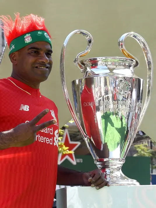 Fans Liverpool berpose di samping piala Liga Champions yang dipamerkan di Kiev, Ukraina , Kamis (24/5). Liverpool akan menghadapi Real Madrid di laga final Liga Champions. (Sergei SUPINSKY/AFP)
