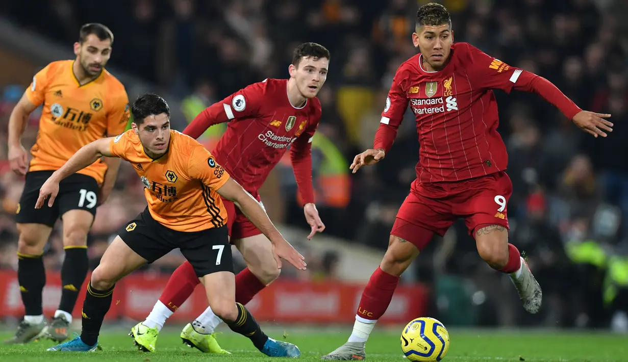 Gelandang Liverpool, Roberto Firmino menghadapi pemain Wolverhampton Wanderers, Pedro Neto pada pekan ke-20 Liga Inggris 2019-2020 di Anfield, Minggu (29/12/2019). Liverpool semakin perkasa di Premier League setelah menang 1-0 atas Wolverhampton. (Paul ELLIS / AFP)