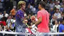 Petenis asal Spanyol, Rafael Nadal dan petenis Rusia, Andrey Rublev berjabat tangan seusai laga perempatfinal turnamen AS Terbuka 2017 di New York, Rabu (6/9). Nadal melangkah ke semifinal usai mengalahkan petenis 19 tahun itu. (Clive Brunskill/AFP)