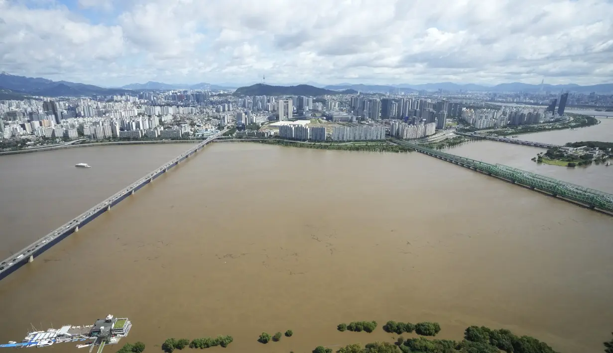 Sungai Han, yang meluap karena banjir, mengalir di bawah jembatan di Seoul, Korea Selatan (6/9/2022). Topan paling kuat yang melanda Korea Selatan selama bertahun-tahun menerjang wilayah selatannya Selasa, membuang satu meter (3 kaki) air hujan, menghancurkan jalan dan meruntuhkan kabel listrik, menyebabkan 66.000 rumah tanpa listrik saat ribuan orang mengungsi ke tempat yang lebih aman. (AP Photo/Ahn Young-joon)