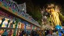 Patung raksasa Dewa Muruga berdiri di sebelah tangga menuju Kuil Batu Caves di Kuala Lumpur, Malaysia, Senin (21/1). Keramaian pengunjung terlihat saat perayaan Festival Thaipusam di lokasi tersebut. (AP Photo/ Vincent Thian)