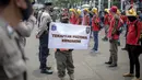 Petugas Satpol PP memegang poster imbauan protokol kesehatan COVID-19 saat unjuk rasa buruh di depan Gedung DPR, Jakarta, Selasa (17/11/2020). Pemerintah terus mengingatkan pentingnya 3M yaitu memakai masker, menjaga jarak, dan mencuci sebagai upaya pencegahan Covid-19. (Liputan6.com/Faizal Fanani)