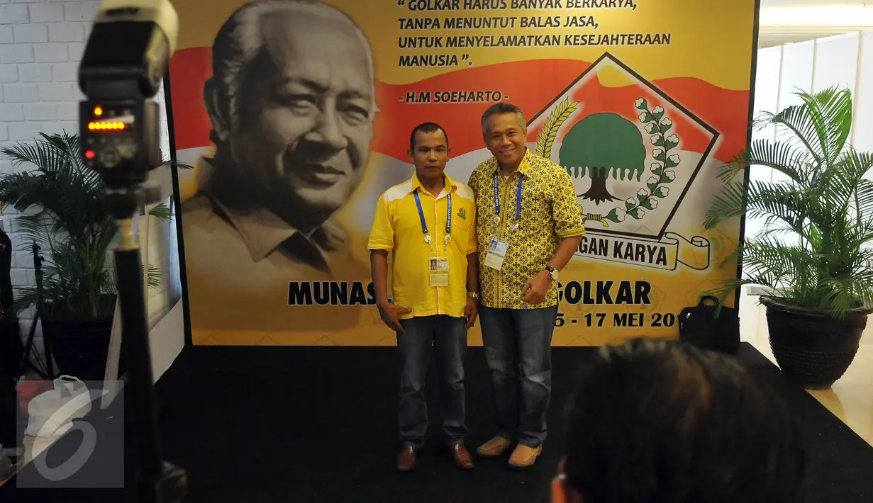 Kader Partai berfoto di depan backdrop Presiden kedua Indonesia, Soeharto saat berlangsungnya Musyawarah Nasional Luar Biasa (Munaslub) Partai Golkar di Bali Nusa Dua Convention Center (BNDCC), Bali, Minggu (15/5). (Liputan6.com/Johan Tallo)