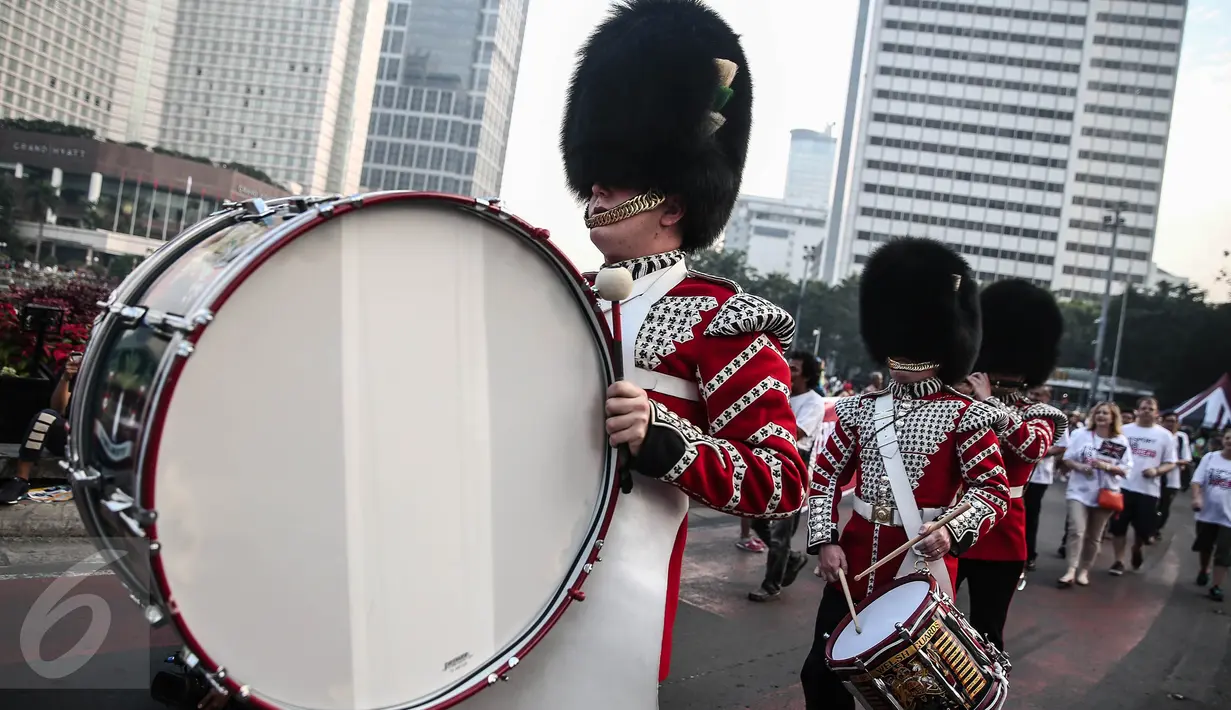 Scotts Guard alias penjaga Buckingham Palace melakukan aksi mengelilingi di Bundaran HI, Jakarta, Minggu (5/6). Aksi Scotts Guard yang didatangkan dari Inggris ini dalam rangka hari ulang tahun Ratu Elizabeth II yang ke-90. (Liputan6.com/Faizal Fanani)