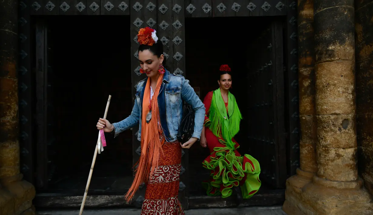 Dua orang wanita mengenakan pakaian tradisional saat mengikuti "Romeria de El Rocio" di Fitero, Spanyol utara (26/5). Mereka mengikuti "Romeria de El Rocio" untuk menghormati Perawan Rocio. (AP/Alvaro Barrientos)