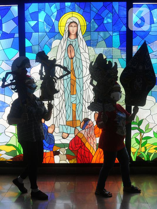 Umat Katolik membawa wayang yang akan dijadikan ornamen dekorasi Natal di Gereja Santo Barnabas, Tangerang Selatan, Banten, Kamis (23/12/2021). Sejumlah gereja di Indonesia mulai melakukan persiapan dan pemasangan dekorasi untuk menyambut misa dan perayaan Natal 2021. (merdeka.com/Arie Basuki)