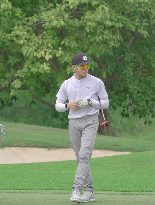 Padu padan kaus polo dan long pants polos jadi semakin menarik dengan kacamata penuh gaya sebagai aksesori.