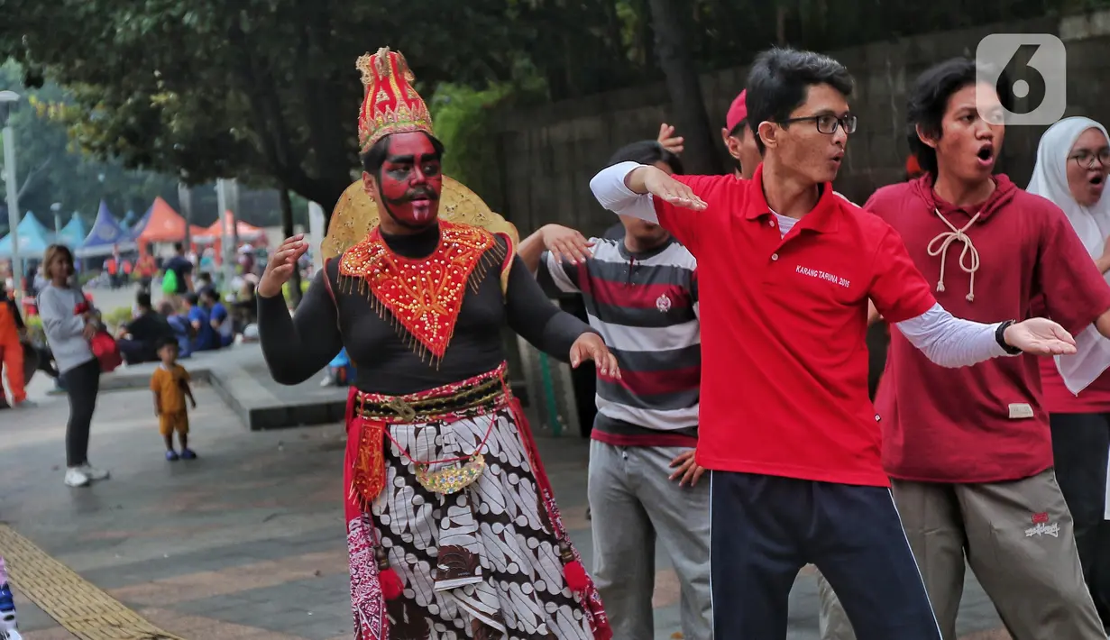 Sejumlah mahasiswa melakukan paduan suara dan gerak tari saat Car Free Day, di Jakarta, Minggu (25/9/2022). Pagelaran ini merupakan bentuk pengenalan seni kepada masyarakat yang tengah melakukan aktivitas di CFD. (Liputan6.com/Angga Yuniar)