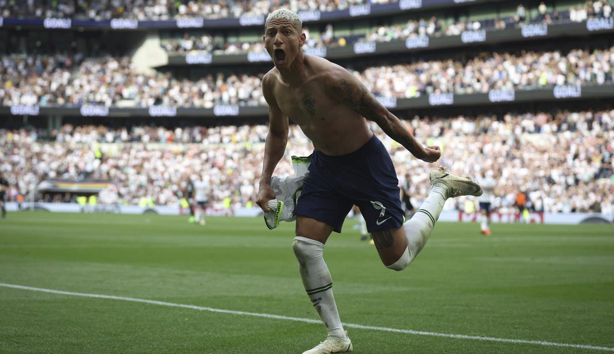Pemain Tottenham Hotspur, Richarlison melakukan selebrasi sambil melepaskan jersey usai menjebol gawang Fulham di menit ke-90. Selebrasi tersebut membuat Richarlison mendapatkan kartu kuning dari wasit karena melanggar aturan. (AP Photo/Ian Walton)