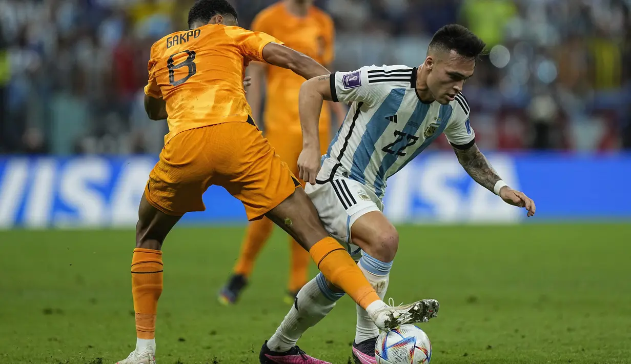 Penyerang Belanda Cody Gakpo berebut bola dengan penyerang Argentina Lautaro Martinez pada babak perempat final Piala Dunia 2022 di Lusail Iconic Stadium, Sabtu (10/12/2022) dinihari WIB. La Albiceleste kini tinggal membutuhkan dua kemenangan lagi untuk memastikan Messi Cs mengangkat trofi juara. (AP Photo/Jorge Saenz)