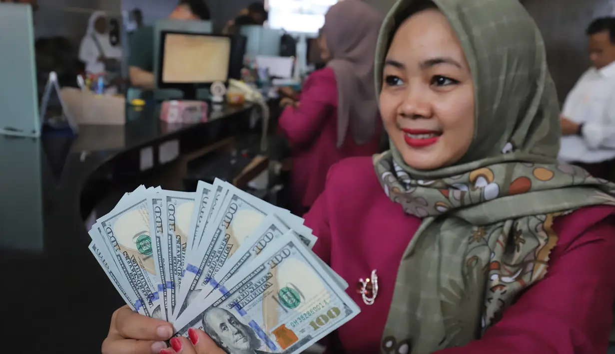 Karyawan menunjukkan lembaran uang Dolar AS di VIP Money Changer, Jakarta, Jumat (5/6/2026). (merdeka.com/Arie Basuki)