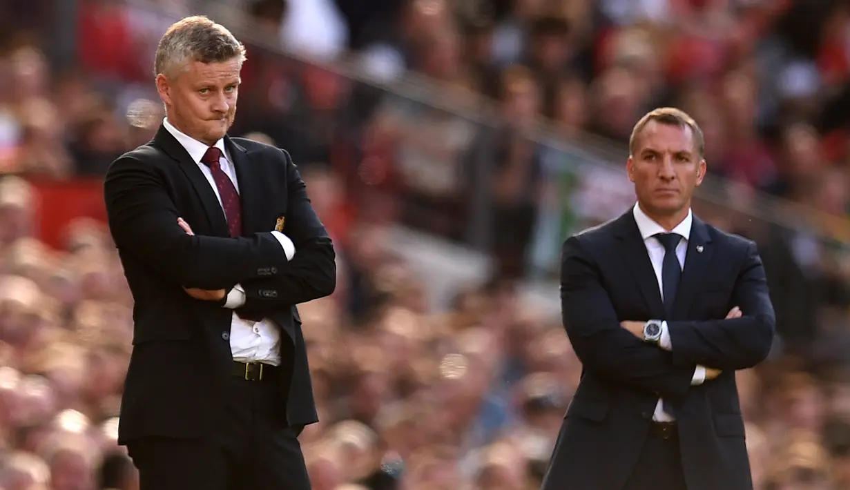 Ekspresi Manajer Manchester United Ole Gunnar Solskjaer (kiri) dan Manajer Leicester City Brendan Rodgers (kanan) saat menyaksikan anak asuh mereka bertanding pada laga Liga Inggris di Stadion Old Trafford, Manchester, Inggris, Sabtu (14/9/2019). MU menang atas Leicester. (Oli SCARFF/AFP)