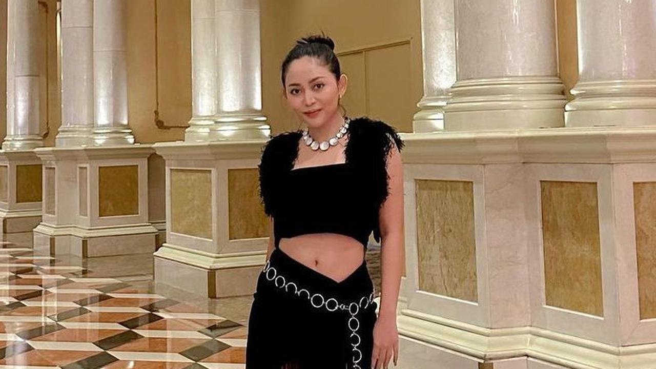 Jika diamati dengan lekat, selama di Amerika Rachel gemar menggunakan hiasan pinggul yang meriah. Di setelan hitam satu ini Rachel mengaplikasikan aksesoris pinggul dengan bentuk rantai agar tampilannya tak membosankan.