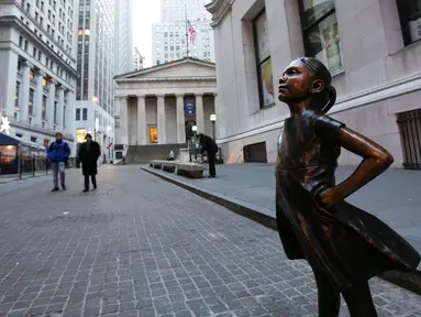 Patung Fearless Girl berdiri di lokasi barunya di depan bursa efek New York, Selasa (11/12). Patung yang menginspirasi jutaan orang dengan pesan feminisme itu sebelumnya berada di depan patung banteng 'Charging Bull' di Broadway. (AP/Mark Lennihan)