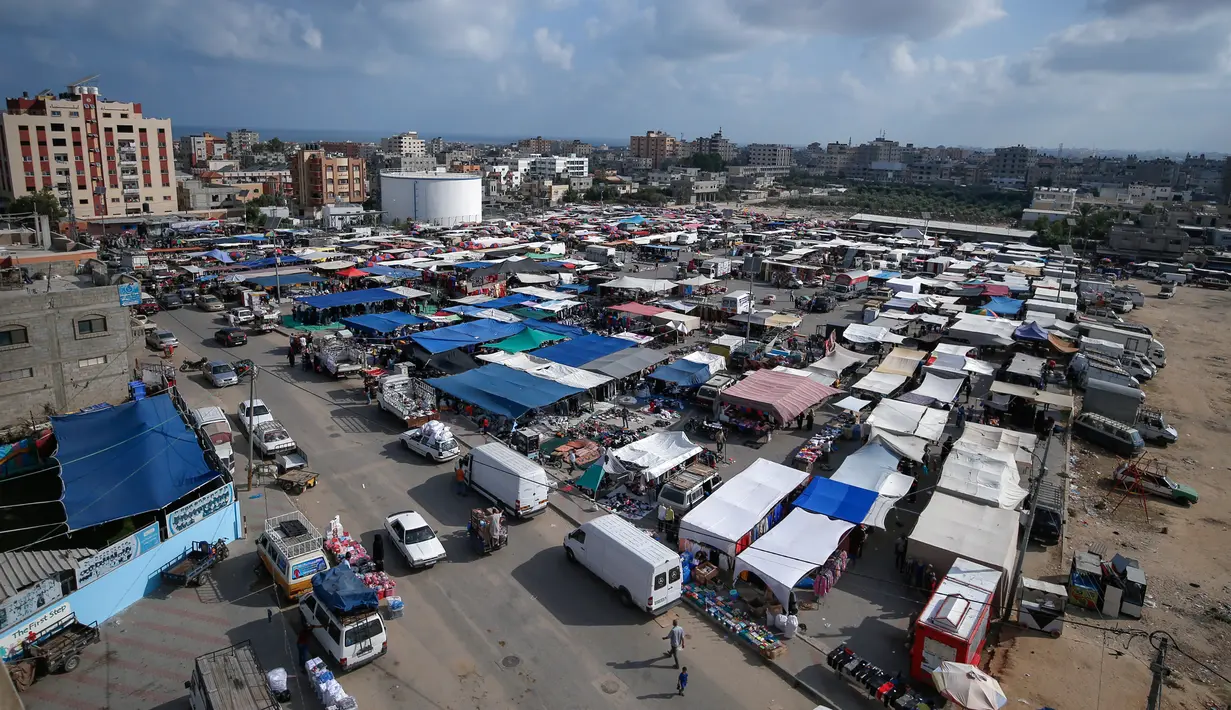 Suasana aktivitas pasar yang kembali ramai setelah pelonggaran karantina wilayah di kamp pengungsi Nuseirat di Jalur Gaza tengah, Senin (13/7/2020). Aktivitas perekonomian seperti kegiatan jual beli di pasar tradisional mulai kembali dibuka. (AFP/Mohammed Abed)