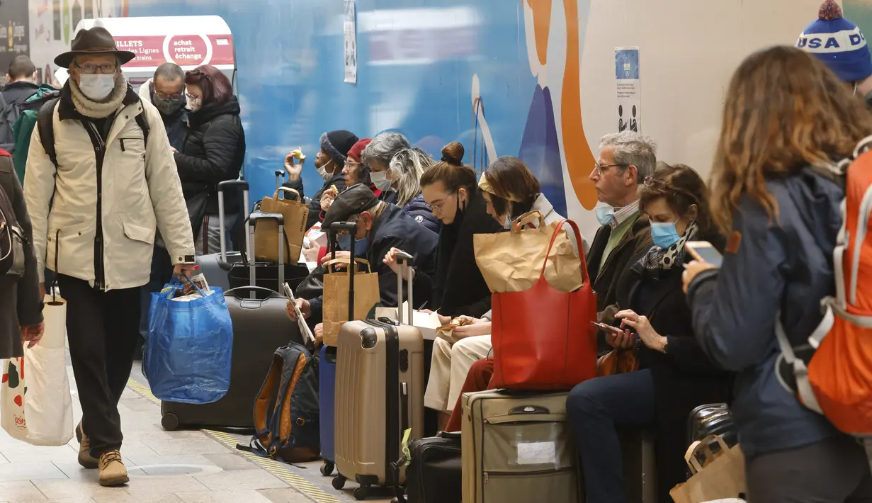Warga Paris menunggu untuk menaiki kereta yang berangkat dari Gare Montparnasse, di Paris, Jumat (19/3/2021). Warga Paris memadati kereta antar kota yang berangkat dari ibu kota beberapa jam sebelum aturan lockdown selama sebulan untuk memerangi lonjakan infeksi COVID-19. (Ludovic MARIN/AFP)