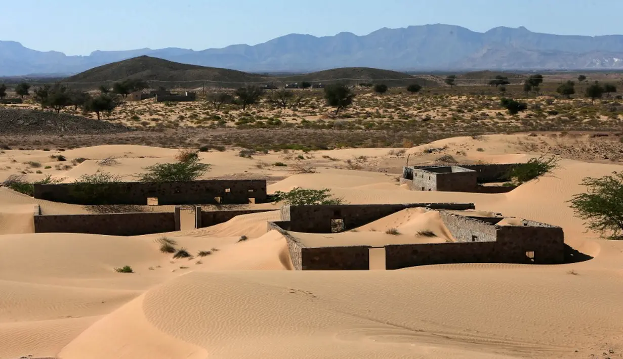 Pemandanan rumah-rumah terlantar di Desa Omani, Wadi al-Murr, Oman, 31 Desember 2020. Menurut tetua setempat, semua rumah di desa itu ditelan pasir pada 30 tahun lalu sehingga memaksa penduduk meninggalkan rumah mereka. (MOHAMMED MAHJOUB/AFP)