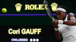 Petenis AS, Cori Gauff mengembalikan bola ke petenis Slovakia, Magdalena Rybarikova pada babak kedua Wimbledon di All England Lawn Tennis Club, London, Rabu (3/7/2019). Petenis muda AS berusia 15 tahun itu melaju ke babak ketiga setelah menaklukkan, Magdalena Rybarikova 6-3, 6-3. (Adrian DENNIS/AFP)