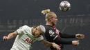 Pemain AC Milan, Simon Kjaer, duel udara dengan pemain Tottenham Hotspur, Richarlison, pada leg pertama babak 16 besar Liga Champions 2022/2023 yang berlangsung di San Siro, Rabu (15/2/2023). (AP Photo/Luca Bruno)