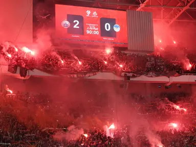 The Jakmania menyalakan Flare saat merayakan kemenangan Persija Jakarta atas PSIM Yogyakarta pada laga pekan ke-14 BRI Super League 2025/2026 di Stadion Utama Gelora Bung Karno, Jakarta, Jumat (28/11/2025) malam. (Bola.com/M Iqbal Ichsan)