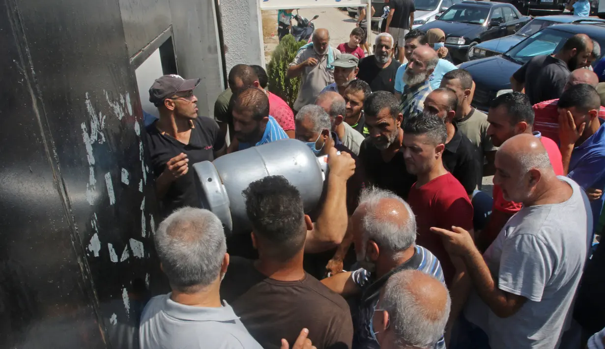Warga Lebanon menunggu untuk mengisi tabung gas di kota selatan Sidon, Selasa (10/8/2021). Warga Lebanon harus mengantre panjang demi membeli gas untuk memasak di tengah krisis ekonomi parah yang memicu kelangkaan berbagai kebutuhan pokok dari obat-obatan hingga bahan bakar. (Mahmoud ZAYYAT/AFP)
