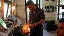 Ibrahim Haji Mohammad, seorang pengungsi Kurdi dari Suriah saat melayani pengunjung di toko cukur miliknya di Budapest, Hongaria, 24 Mei 2016. (REUTERS / Laszlo Balogh)
