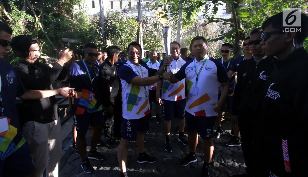 Dirut Bank Mandiri Darmawan Junaidi (kanan) bersiap membawa obor Asian Games 2018, Bali, Selasa (24/7). Mandiri Inhealth juga menyiapkan askes seluruh atlet, official dan media dari 45 negara peserta Asian Games. (Liputan6.com/Pool/Rizki)