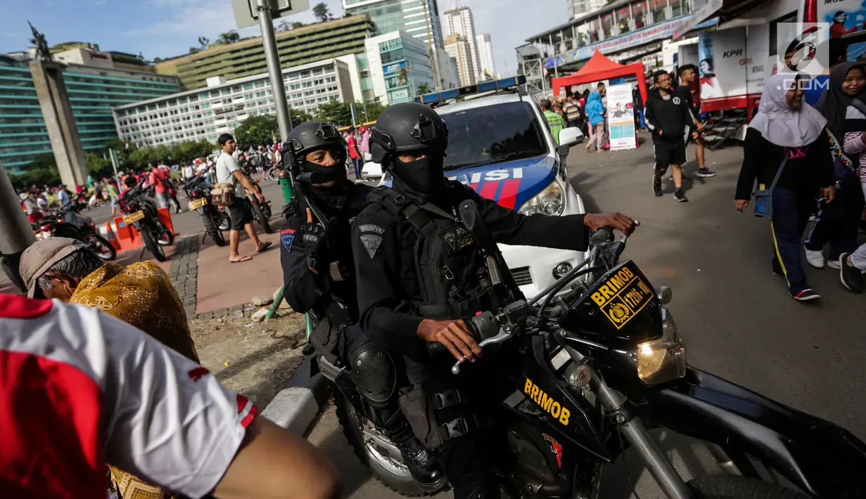 Sejumlah pasukan Brimob mengendarai motor dan bersenjata lengkap berpatroli saat Car Free Day di kawasan Bunderan HI, Jakarta, Minggu (24/12). (Liputan6.com/Faizal Fanani)