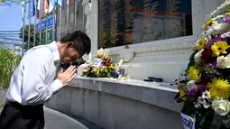 Pejabat konsulat Jepang berdoa di Monumen Bom Bali, Kuta, dekat Denpasar pada Sabtu (12/10/2019). MeMperingati 18 tahun peristiwa bom Bali yang terjadi pada 12 Oktober 2002, wisatawan dan kerabat korban mengunjungi tugu peringatan untuk berdoa dan tabur bunga. (SONNY TUMBELAKA / AFP)