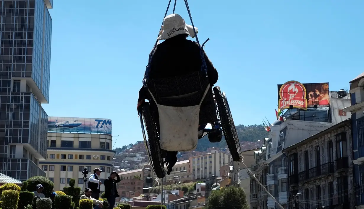 Seorang wanita penyandang cacat melakukan aksi menggantungkan diri disebuah jembatan di La Paz, Bolivia (3/5). Sejumlah wanita penyandang cacat nekat gantung diri saat aksi menuntut pemberian subsidi dari pemerintah. (REUTERS/David Mercado)