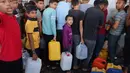 Anak-anak pengungsi Palestina memegang wadah sambil menunggu waktu mengambil air, di Khan Yunis, di Jalur Gaza selatan pada 26 Oktober 2023. (MOHAMMED ABED/AFP)