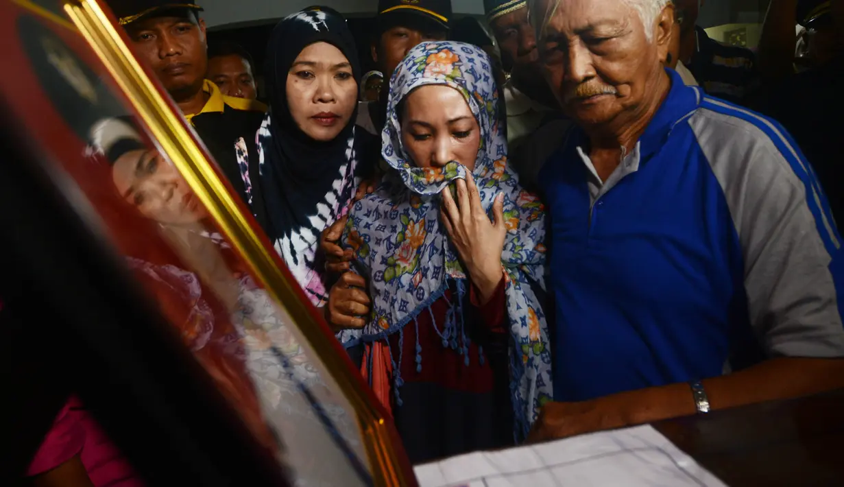 Reaksi istri (tengah) menyambut kedatangan jenazah Yudhistira Febbi Arianto, co pilot pesawat Aviastar di masjid dekat Bandara Ngurah rai, Bali, Kamis (8/10). Pesawat Aviastar jatuh dan menewaskan 3 kru dan 7 penumpang. (AFP PHOTO/SONNY TUMBELAKA)