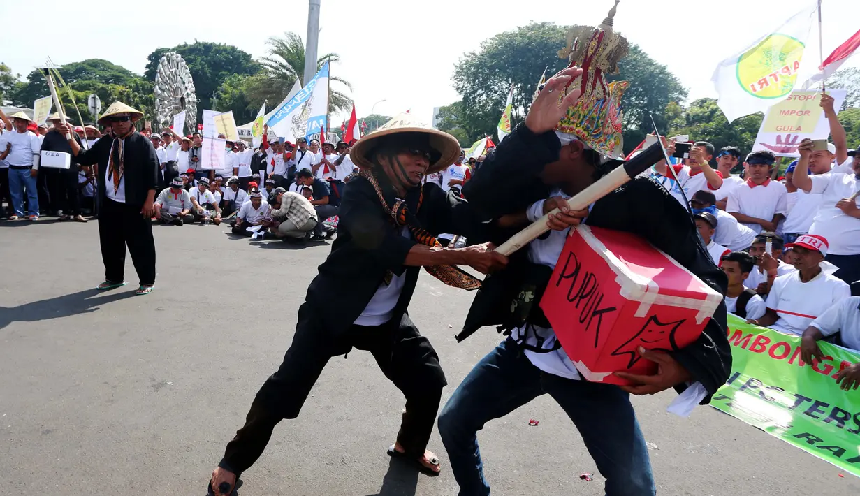 Petani tebu melakukan aksi tearikal saat unjuk rasa di depan Istana Merdeka, Jakarta, Senin (28/8). Aksi ini dilakukan lantaran dinilai belum ada upaya pemerintah membantu petani, khususnya harga gula lokal yang semakin rendah. (Liputan6.com/Angga Yuniar)