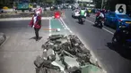 Pejalan kaki melintas di samping jalur sepeda yang di bongkar di kawasan Cikini, Jakarta, Selasa (19/11/2019). Jalur sepeda berumur 2 bulan tersebut dibongkar akibat proyek pelebaran trotoar. (Liputan6.com/Faizal Fanani)