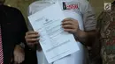 Seniman, Dhani Ahmad Prasetyo menunjukkan surat laporan usai membuat pelaporan dugaan persekusi di Bareskrim Mabes Polri Gedung KKP, Jakarta, Jumat (19/10). Dhani Ahmad merasa mendapat n persekusi saat di Surabaya. (Liputan6.com/Helmi Fithriansyah)
