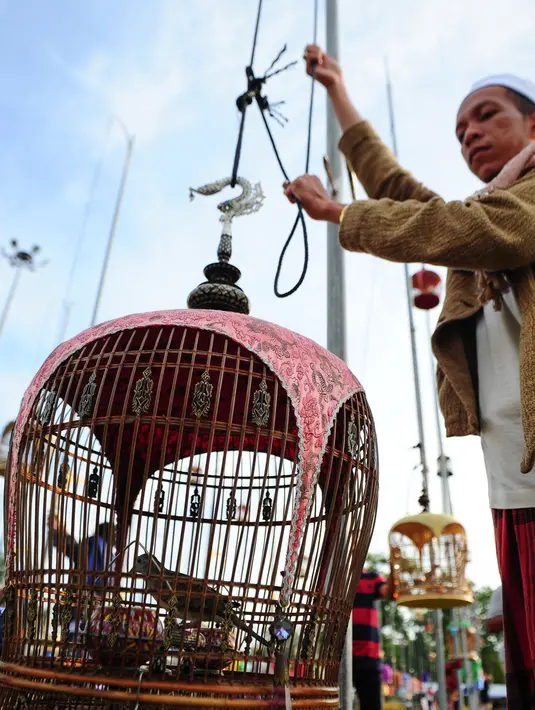 Peserta mempersiapkan burung peliharaanya saat mengikuti kontes kicau burung di provinsi Narathiwat, Thailand (18/9). Lebih dari 1.400 burung dari Thailand, Malaysia dan Singapura ikut serta dalam kontes tahunan tersebut. (AFP Photo/Madaree Tohlala)