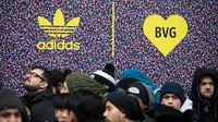 Calon pembeli mengantre untuk mendapatkan sepatu Adidas/BVG (Berlin Transport) di luar toko Overkill di Berlin, Jerman, Selasa (16/1). Sepatu tersebut dijual dengan harga 180 Euro atau sekitar Rp 2,95 juta. (AFP PHOTO / Odd ANDERSEN)
