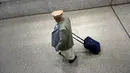 Seorang pria meninggalkan ruang kedatangan Bandara Dulles, Washington, Senin (6/2). Sebuah pengadilan banding AS di San Fransisco menolak permintaan Kementerian Kehakiman untuk memberlakukan kembali kebijakan anti-imigran Trump. (Brendan Smialowski/AFP)