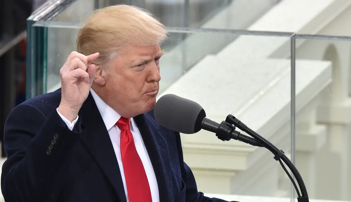 Donald Trump menyampaikan pidato pertamanya usai dilantik menjadi presiden di Capitol Hill, Washington DC, AS, Jumat (20/1). Menurut Trump pergantian presiden adalah mentransfer kekuatan dari Washington DC kepada warga AS. (AFP Photo)