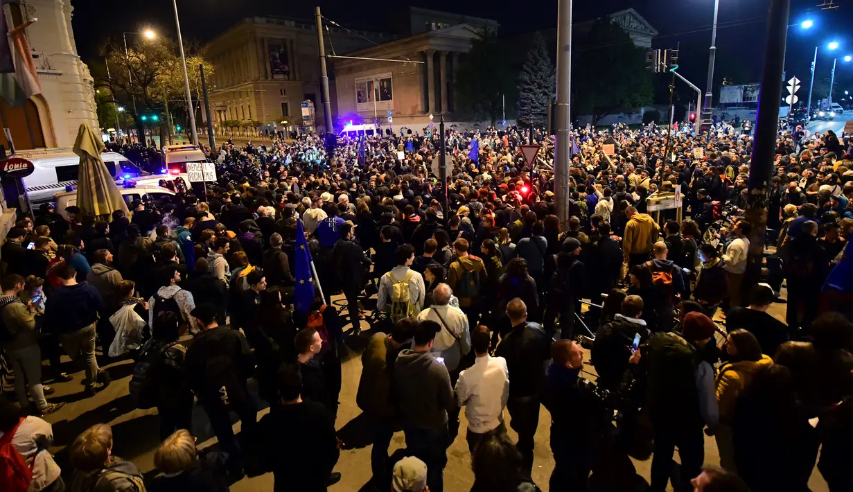 Warga Hungaria turun ke jalan di Budapest untuk menyuarakan penolakan mereka terhadap kebijakan baru pemerintah, Hungaria, Minggu (9/4). (AFP PHOTO/ATTILA KISBENEDEK)