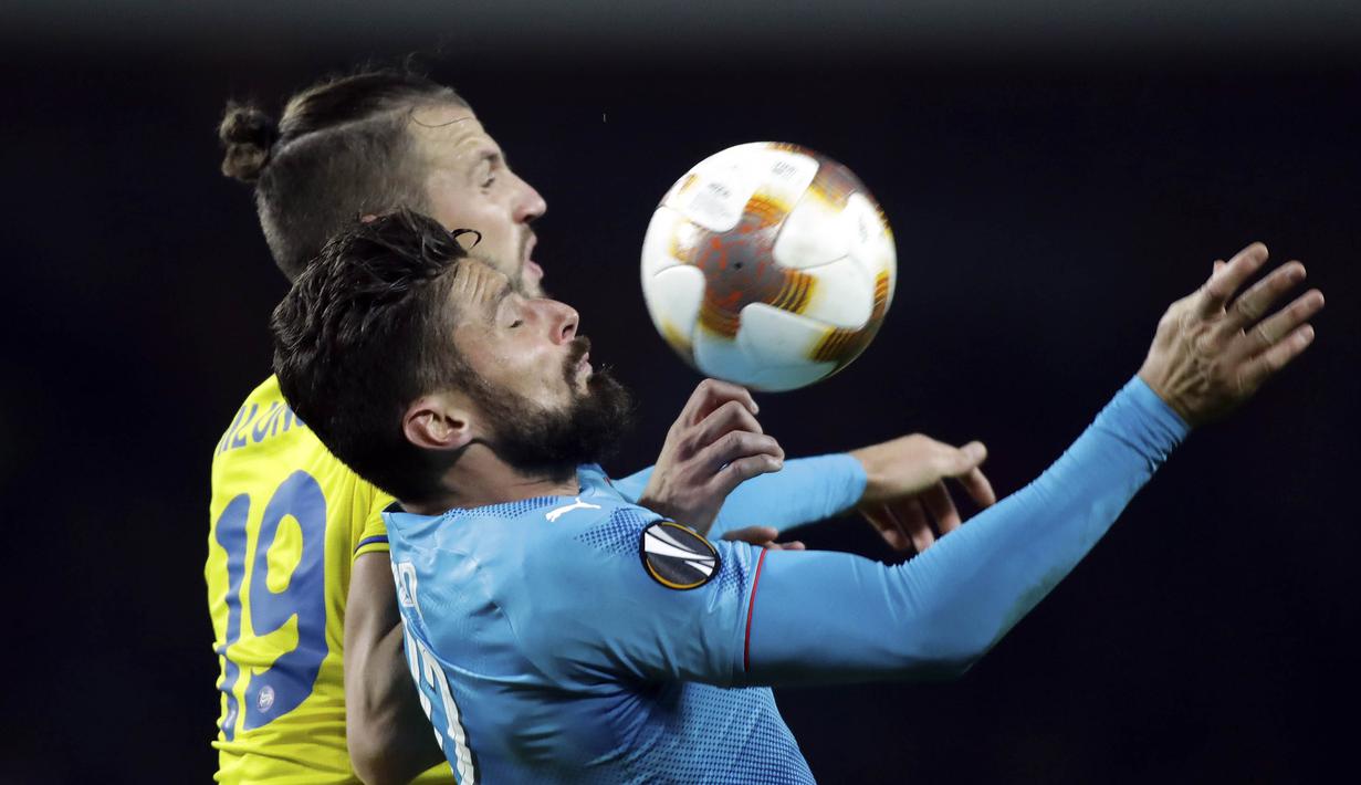 Striker Arsenal, Olivier Giroud, duel udara dengan bek BATE Borisov, Nemanja Milunovic, pada laga Liga Europa di Stadion Borisov, Kamis (28/9/2017). Arsenal menang 4-2 atas BATE Borisov. (AP/Sergei Grits)