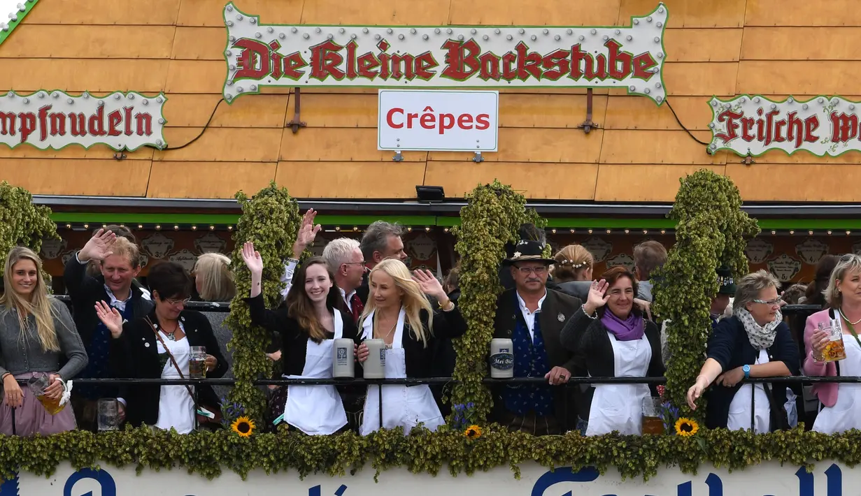 Anggota dewan melambai dari balkon saat pembukaan festival bir terbesar di dunia Oktoberfest ke-185 di Munich, Jerman, Sabtu (22/9). (Christof STACHE/AFP)