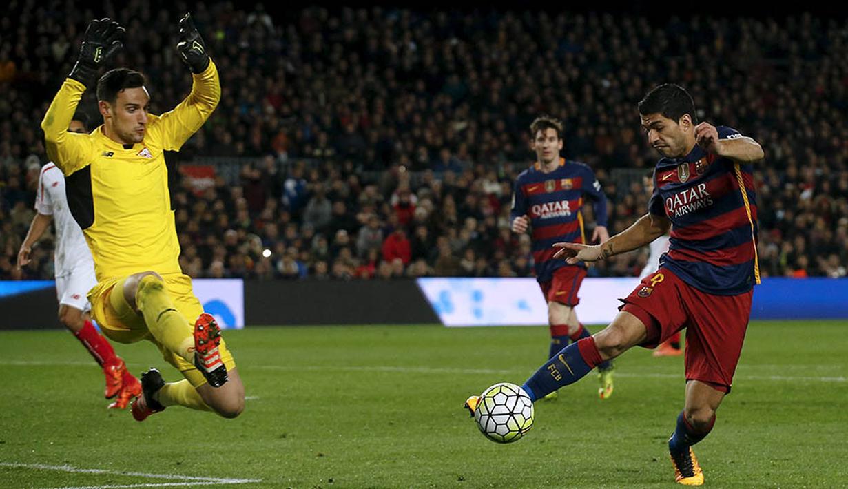 Gerakan striker Barcelona, Luis Suarez, mengecoh kiper Sevilla, Sergio Rico. Pada laga itu Suarez berhasil menyumbang sebuah assist. (Reuters/Albert Gea)
