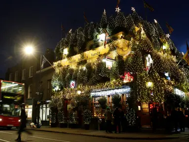 Pohon natal menutupi bagian luar bangunan bar The Churchill Arms di London, Inggris, 20 Desember 2016. Dalam rangka menyambut Natal, lebih dari 80 pohon natal dan hampir 22.000 lampu berkelap-kelip tampak menghiasi bar tersebut. (REUTERS/Neil Hall)