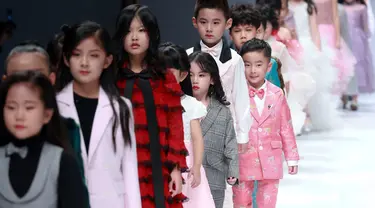 Model anak-anak membawakan busana rancangan KUNJIE oleh Liu Shuming  pada gelaran China Fashion Week di Beijing, China, Selasa (27/10/2020). (STR / AFP)